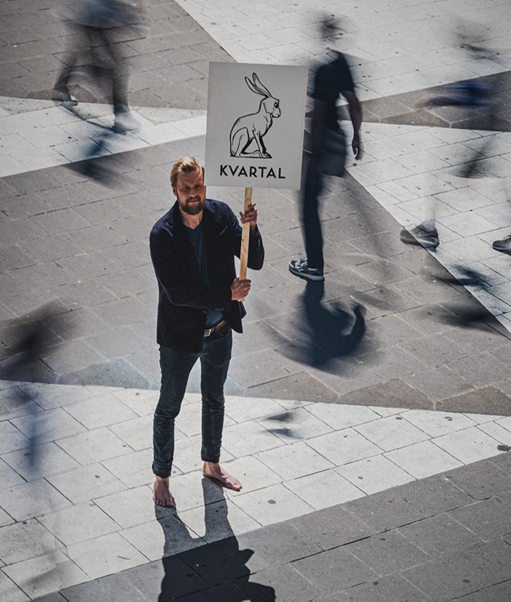 Magnus håller ett Kvartal-plakat på Sergels torg